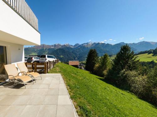 a patio with chairs and a view of the mountains at Natürlich Hotel mit Charakter in Fiss
