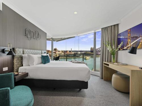 a hotel room with a bed and a large window at Pullman Quay Grand Sydney Harbour in Sydney