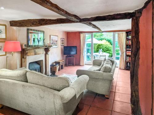 a living room with couches and a fireplace at Stable End in Halesworth