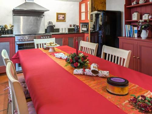 a kitchen with a table with a red table cloth at Stable End in Halesworth