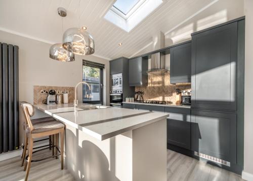 a kitchen with black cabinets and a white counter top at Faringdon Grange in Faringdon