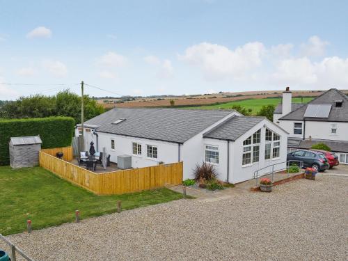 a white house with a fence in a yard at Magpie Cottage in Gristhorpe