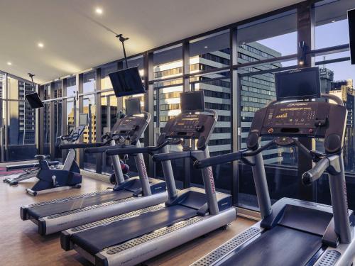 a gym with several tread machines in a building at Mercure Brisbane King George Square in Brisbane