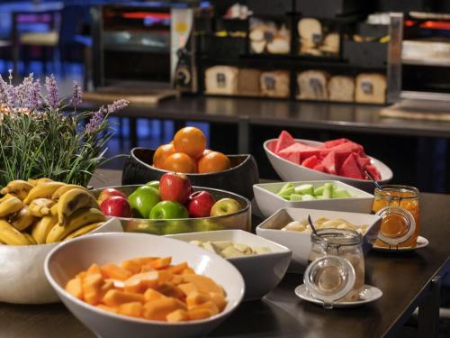 a buffet with bowls of fruits and vegetables on a table at Mercure Brisbane King George Square in Brisbane