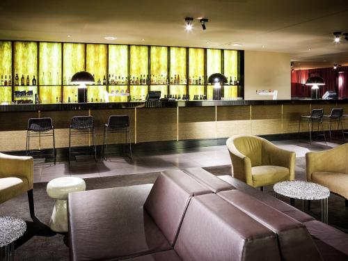 a lobby with a bar with a couch and chairs at Mercure Brisbane King George Square in Brisbane