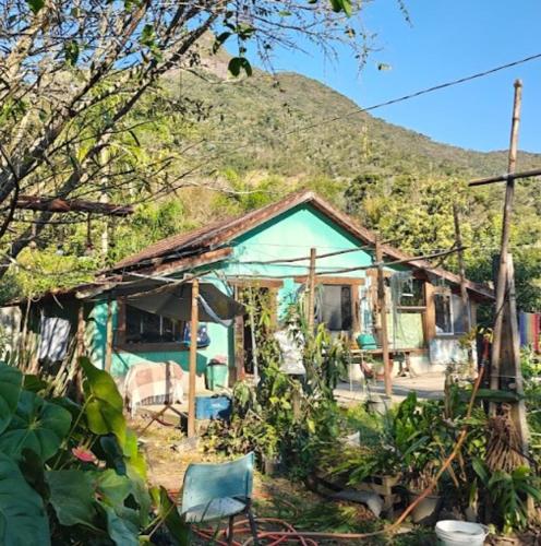 a green house with a mountain in the background at Glamping SixtyNine Hundred in Nova Friburgo