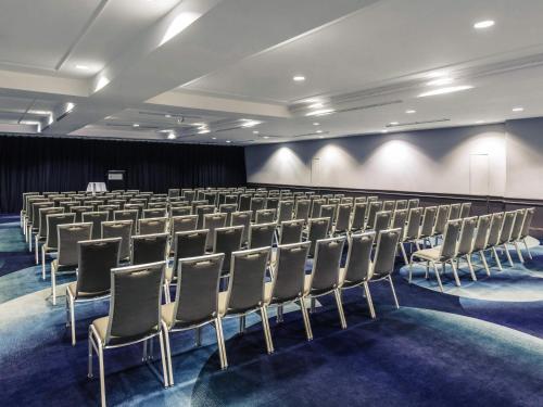 a conference room with a row of chairs in it at Mercure Brisbane King George Square in Brisbane