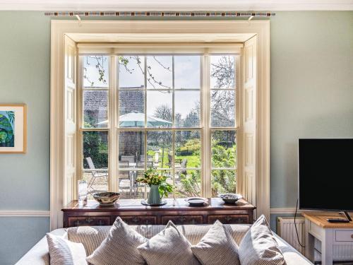 a living room with a couch and a large window at Hemblington Hall Arts And Leisure Ltd in South Walsham