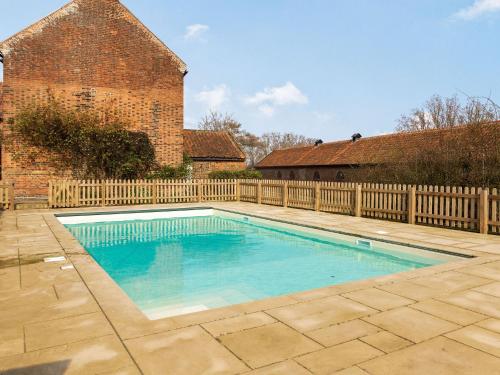a swimming pool in a yard with a wooden fence at Hemblington Hall Arts And Leisure Ltd in South Walsham