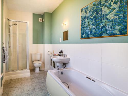 a bathroom with a tub and a sink and a toilet at Hemblington Hall Arts And Leisure Ltd in South Walsham