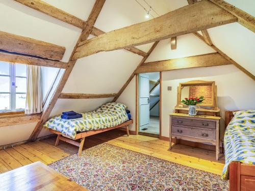 a attic room with a bed and a mirror at Hemblington Hall Arts And Leisure Ltd in South Walsham