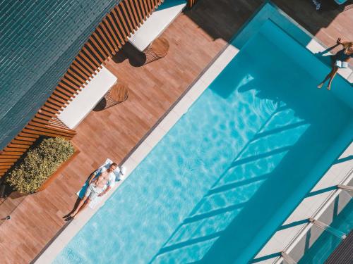 an overhead view of a swimming pool with people standing around it at Pullman Brisbane King George Square in Brisbane