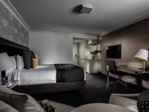 a hotel room with a bed and a desk at Pullman Brisbane King George Square in Brisbane