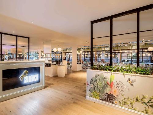 a store with a large tv in a room with plants at Pullman Brisbane King George Square in Brisbane