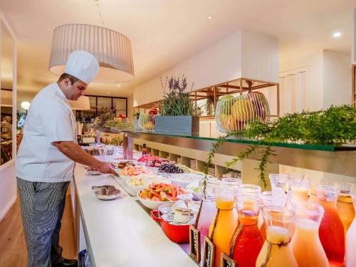 a chef preparing a buffet of food in a kitchen at Pullman Brisbane King George Square in Brisbane