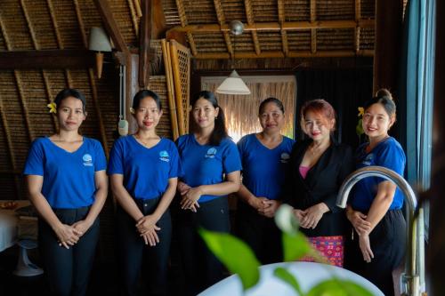 a group of women in blue shirts posing for a picture at Amed Cafe & Hotel Kebun Wayan in Amed