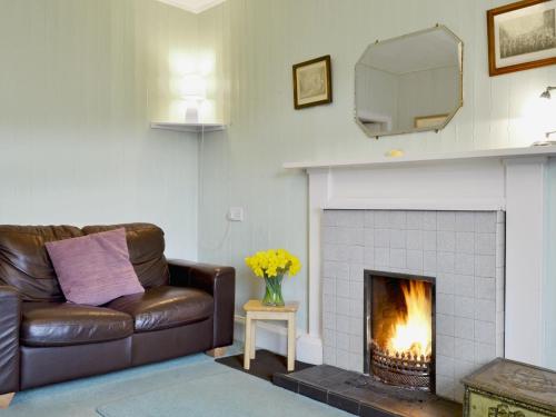 a living room with a couch and a fireplace at Tigh-An-Achaidh in Inverinate