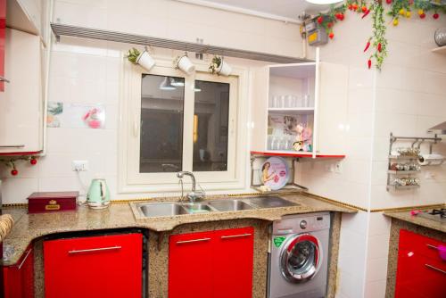a kitchen with a sink and a washing machine at Luxurious Family Apartment in Prime New Cairo with Garden in Cairo