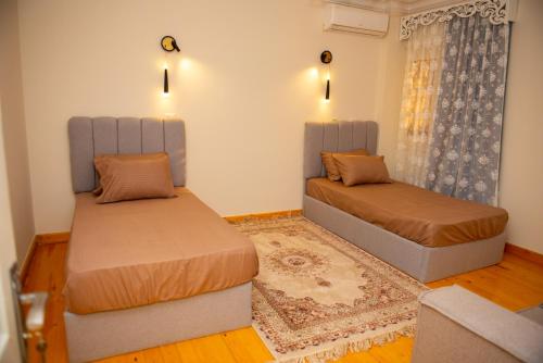a bedroom with two beds and a couch at Luxurious Family Apartment in Prime New Cairo with Garden in Cairo