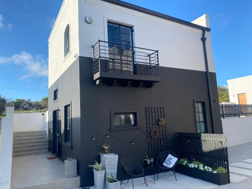 a black and white house with a balcony at Bellamore - Stylish Loft Studio with Sea Views in Brenton-on-Sea
