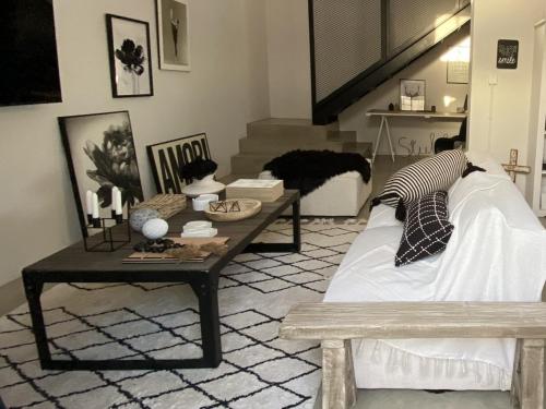 a living room with a couch and a coffee table at Bellamore - Stylish Loft Studio with Sea Views in Brenton-on-Sea