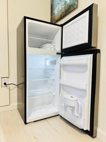 an empty refrigerator with its door open in a room at 1 Bedroom Mini Apartment 10 Minutes to SeaTac Airport 1 Minute Walk to Bus Station in Seattle