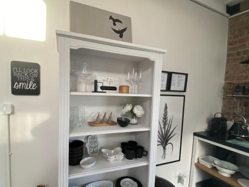 a white shelf with items on it in a room at Bellamore - Stylish Loft Studio with Sea Views in Brenton-on-Sea