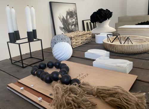 a table with black and white vases and candles at Bellamore - Stylish Loft Studio with Sea Views in Brenton-on-Sea