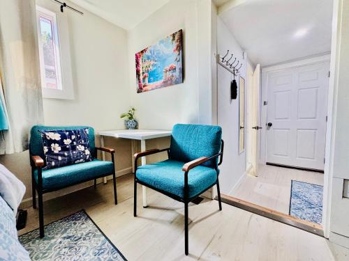 two blue chairs in a room with a table at 1 Bedroom Mini Apartment 10 Minutes to SeaTac Airport 1 Minute Walk to Bus Station in Seattle