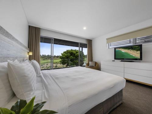 a bedroom with a large bed and a television at Pullman Magenta Shores Resort in The Entrance