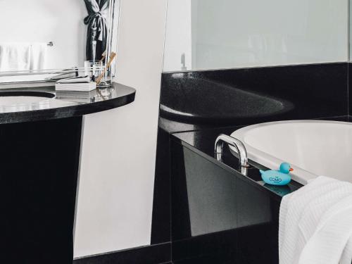 a bathroom with a sink and a bath tub at The Como Melbourne in Melbourne