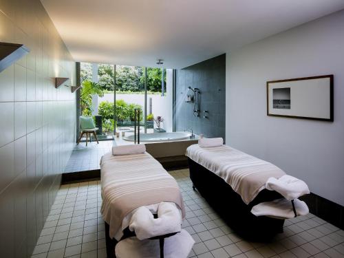 a bathroom with two beds and a bath tub at Pullman Magenta Shores Resort in The Entrance