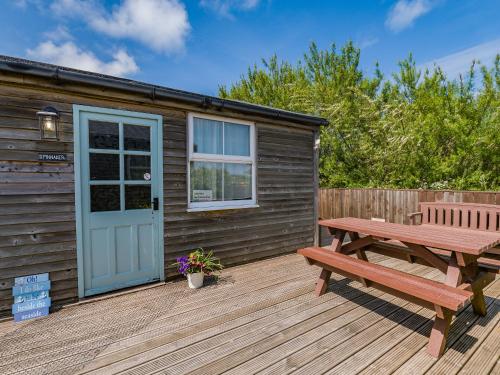 a wooden cabin with a picnic table and a bench at Spinnaker - 16828 in Staithes