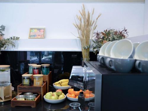 a kitchen with bowls of fruit and plates on a microwave at The Como Melbourne in Melbourne
