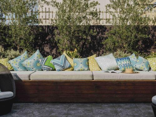 a couch filled with colorful pillows sitting on a patio at The Como Melbourne in Melbourne