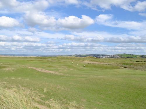a golf course with sheep grazing in a field at The Stables in Abbots Bickington
