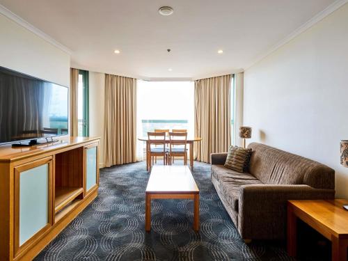 a living room with a couch and a tv at The Sebel Sydney Chatswood in Sydney