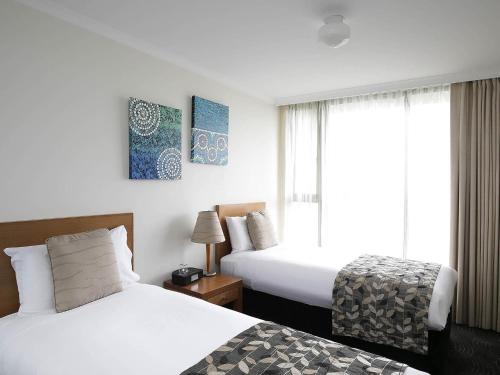 a hotel room with two beds and a window at The Sebel Sydney Chatswood in Sydney