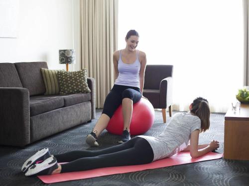 two women sitting on a ball in a living room at The Sebel Sydney Chatswood in Sydney