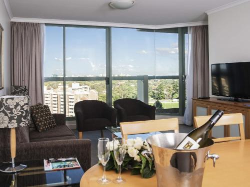 a living room with a bottle of wine on a table at The Sebel Sydney Chatswood in Sydney