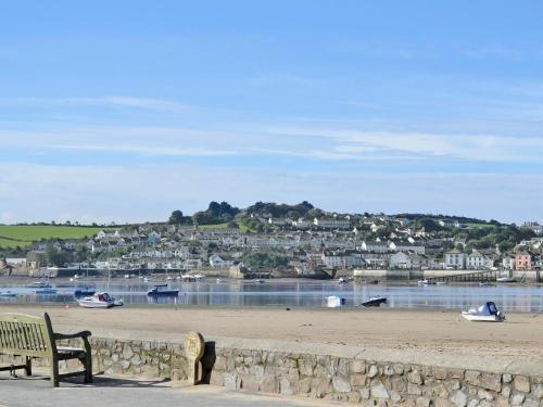 a bench sitting on a beach near a body of water at Midships in Instow