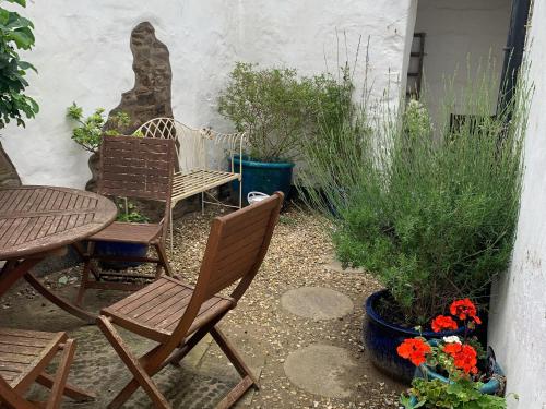 a patio with two chairs and a table and flowers at Midships in Instow
