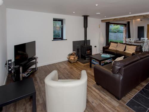 a living room with a couch and a fireplace at West Barns - Fernhill Farm in Wootton Bridge