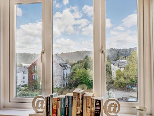 un estante de libros delante de una ventana en Strawberries And Cream, en Bowness-on-Windermere