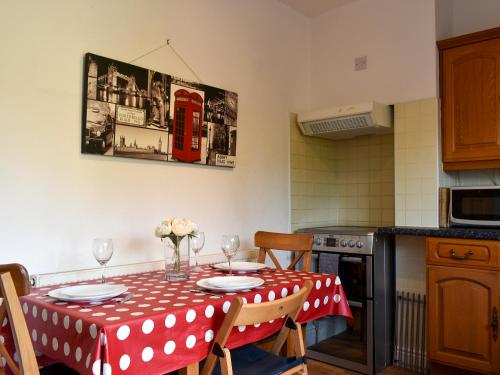 a kitchen with a table with a red polka dot table cloth at Shingle Cottage in Whitstable