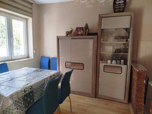 a dining room with a table and a cabinet at Apartment "Daisy Flower" - Center, Bitola in Bitola