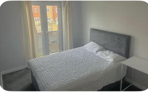 a bedroom with a bed and a large window at Shekinah glory in Stockton-on-Tees