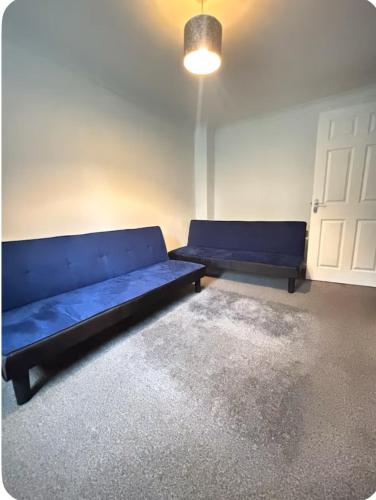 a room with a blue couch and a white door at Shekinah glory in Stockton-on-Tees