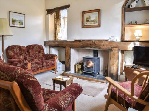 a living room with a couch and a fireplace at Yew Tree Cottage in Windermere