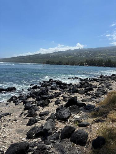 a group of rocks on the shore of a body of water at Le meublé du Sable Nwar in Étang-Salé